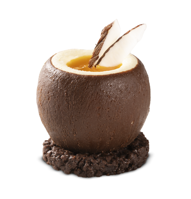Cáscara redonda de chocolate rellena de curd de naranja, decorada con finas láminas de chocolate blanco y negro, sobr...