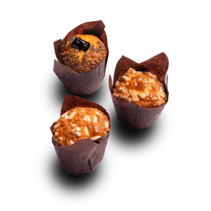 Tres muffins en moldes tulipán marrones: amapola con frutos rojos, crumble con mermelada y almendras, fondo blanco.
