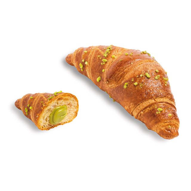 Croissant dorado cubierto con pistacho triturado, con relleno cremoso verde de pistacho a la vista