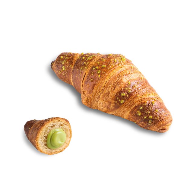 Croissant dorado cubierto con crocante de pistacho, con un trozo pequeño abierto mostrando el relleno cremoso verde d...
