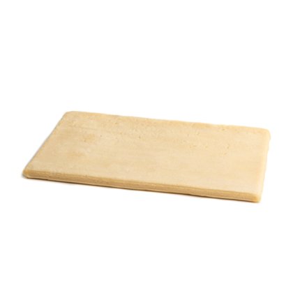 Plancha rectangular plana de masa cruda pálida sobre fondo blanco