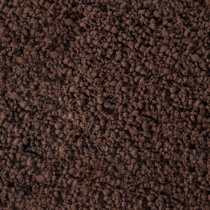 Primer plano de superficie marrón oscuro y desmenuzable, similar a tierra gruesa o posos de café.