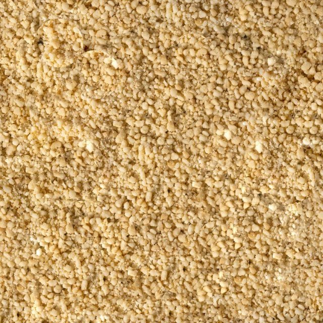 Primer plano de polvo amarillo pálido fino y granulado, con textura áspera y desmenuzable en todo el encuadre.