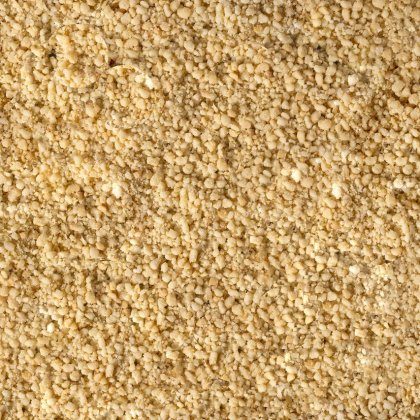 Primer plano de polvo amarillo pálido fino y granulado, con textura áspera y desmenuzable en todo el encuadre.