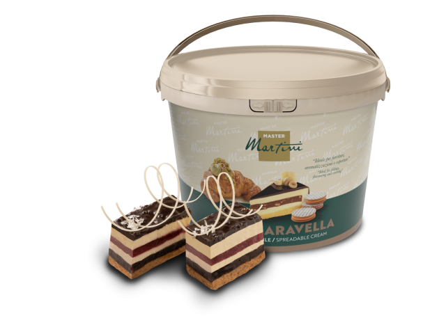 Cubo grande de crema untable Master Martini "Aravella" junto a dos porciones de tarta en capas con virutas de chocolate.