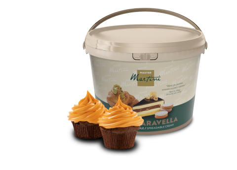 Cubo beige de crema para untar Master Martini con dos cupcakes de chocolate cubiertos de glaseado naranja delante.
