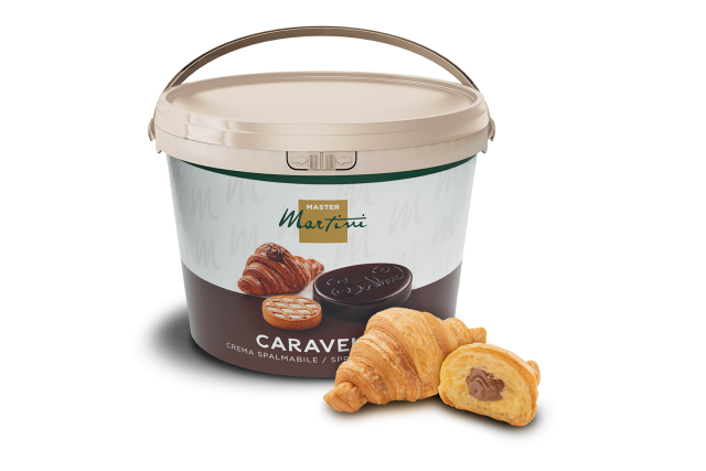 Cubo beige de crema de chocolate para untar Master Martini Caravel junto a dos croissants, uno con chocolate.