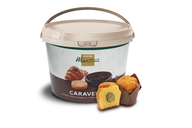Cubo grande de crema untable Master Martini Caravel junto a un muffin cortado relleno de crema y otro entero.