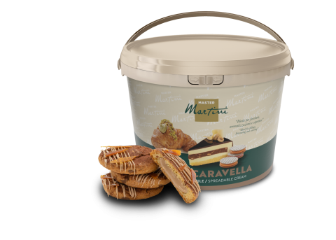 Cubo grande de crema untable Master Martini Caravella junto a pasteles rellenos con chocolate blanco.