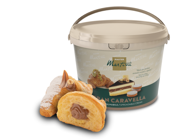 Cubo grande de crema para untar Master Martini Gran Caravella junto a dos pasteles rellenos de crema espolvoreados co...