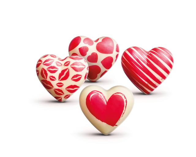 Cuatro chocolates blancos con forma de corazón decorados con marcas de labios rojos, corazones, rayas y un corazón pi...