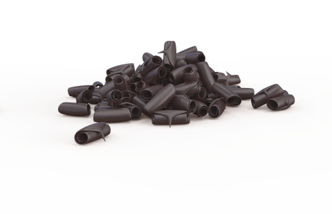 Pequeñas tapas de plástico negro en forma de tubo esparcidas sobre fondo blanco