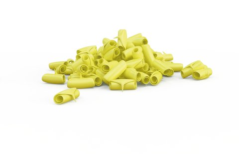 Un montón de pasta tubular amarilla y curvada, similar al rigatoni, esparcida sobre fondo blanco.