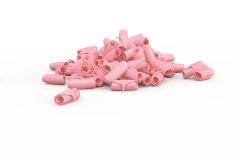 Trozos de chicle rosa en forma de tubo esparcidos sobre fondo blanco