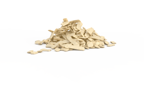 Montón de escamas beige de forma irregular sobre fondo blanco liso.