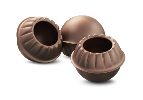 Tres cáscaras redondas de chocolate vacías, con bordes ondulados y centro hueco, sobre fondo blanco.